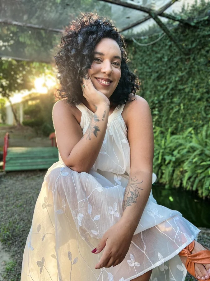 Luna Rocha, psicóloga clínica, sorrindo em ambiente externo